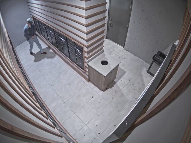 The male walks towards the exit of the mail room while buckling his pants. The male walks towards the exit of the mail room while buckling his pants.