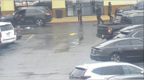 The suspect holds his hands above his head as police officers approach. The suspect holds his hands above his head as police officers approach.