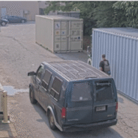 The van drives behind the commercial property to approach the private dumpster. The van drives behind the commercial property to approach the private dumpster.