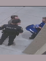 The police officer and a medic speak to the injured male outside of the apartment complex.