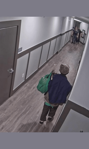 Police officers approach the suspect in the apartment complex.