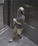 The injured male is standing in the elevator holding his right shoe. He is bleeding from his face and legs, and appears to be bruised on his right leg and unable to put weight on it.