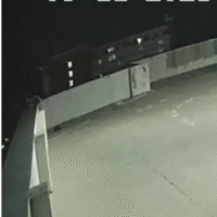 The male climbs onto the ledge of the top floor of the parking deck. The male climbs onto the ledge of the top floor of the parking deck.