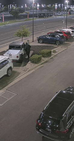 The second suspect approaches the white Jeep truck and enters the vehicle.