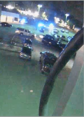 Five police vehicles enter the parking lot, causing vehicles to flee the area.